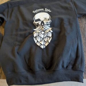 Black Skull Hop Beard Tee, showcasing a skull with a beard design and the text "Baksan Lake Project Oberstdorf," displayed on a wooden surface.