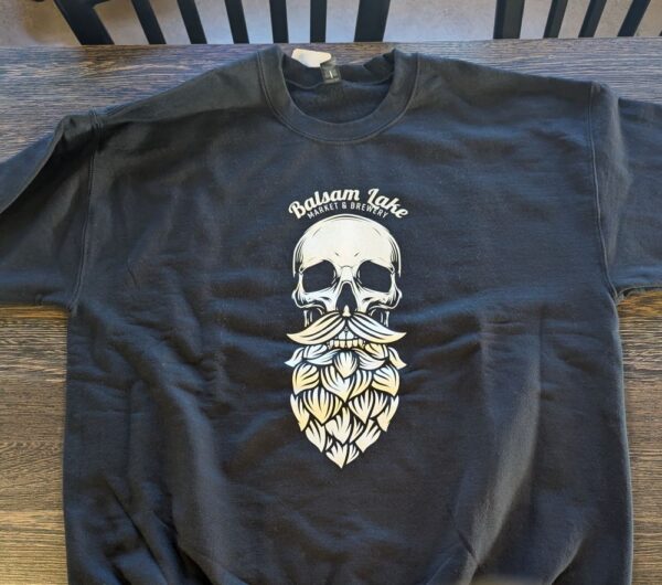 Black Crewneck Sweatshirt Skull showcasing a graphic skull with a leaf beard and the words "Balsam Lake Market & Brewery" above it.