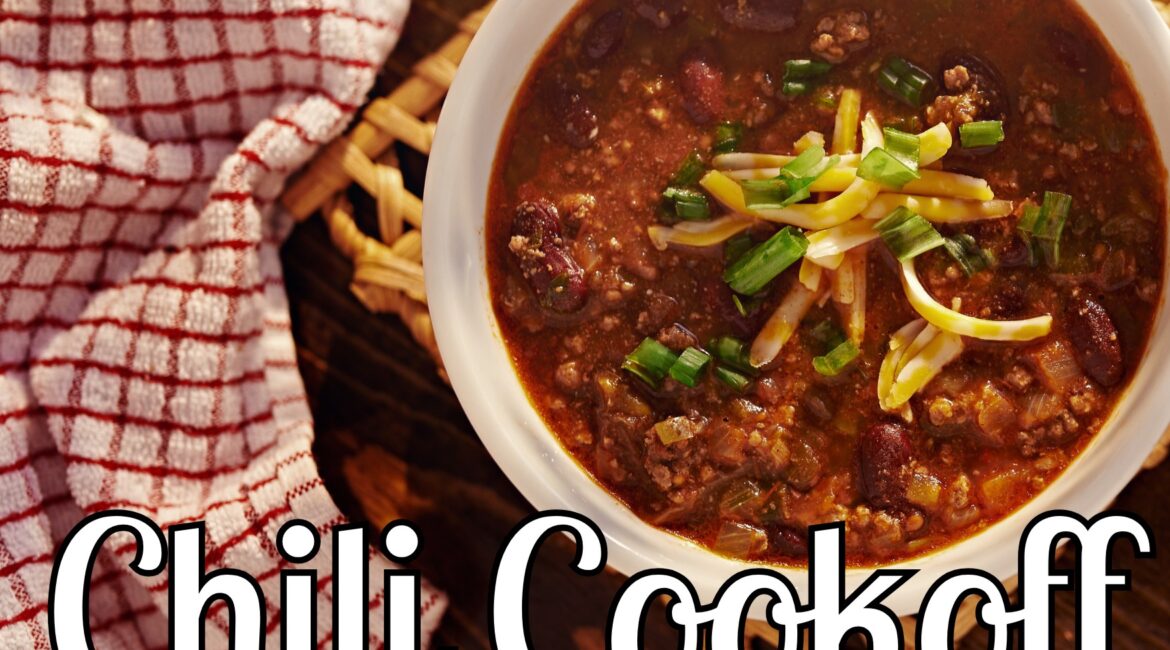 A bowl of chili with cheese and green onions, on a wooden table with a red and white towel. Text reads: "Chili Cookoff December 29th at noon.